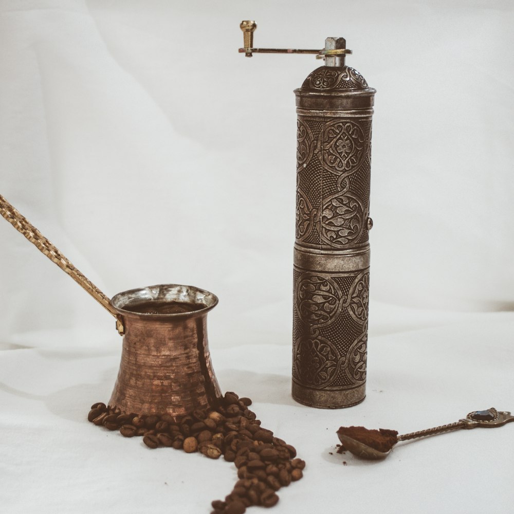 brown and silver steel candle holder beside brown wooden stick