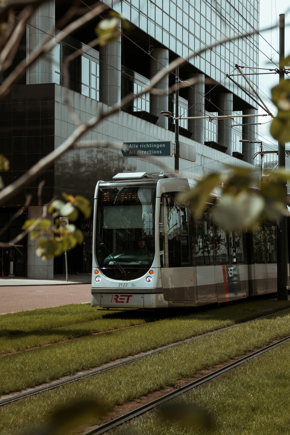 white and blue train on the street during daytime