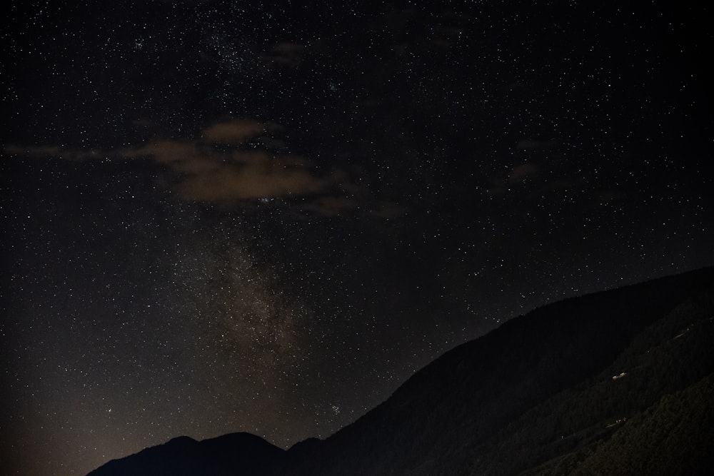 silhouette of mountain under starry night