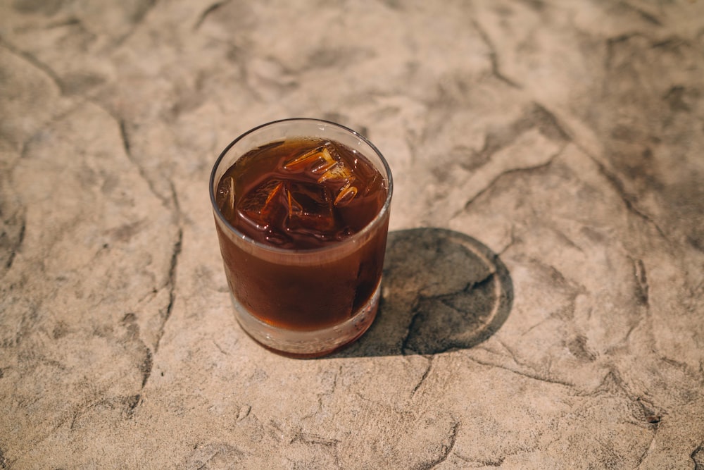 clear drinking glass with brown liquid