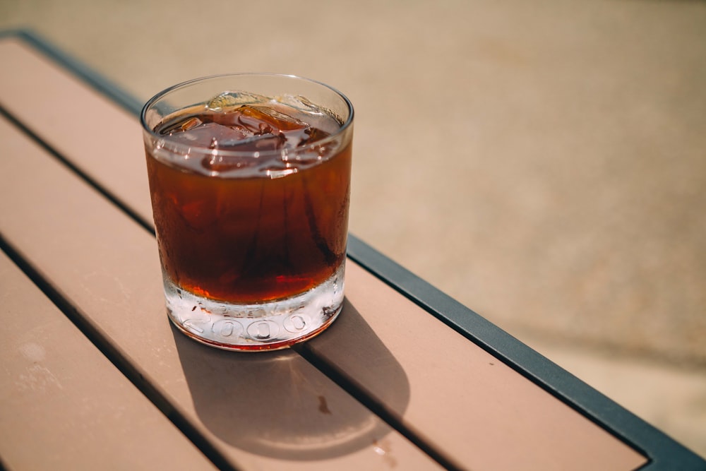 clear drinking glass with brown liquid