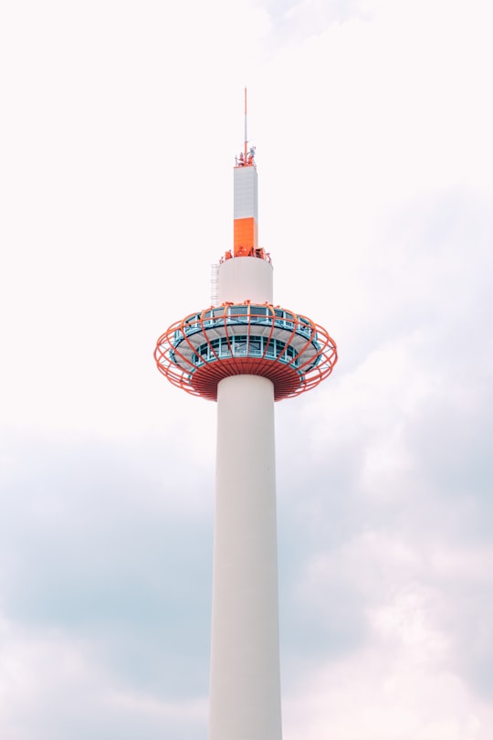 white and red tower under white clouds in Kyoto Tower Japan