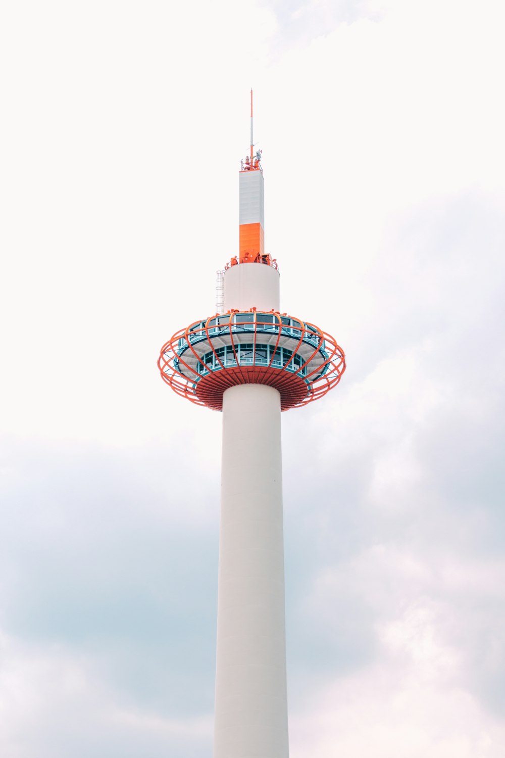 white and red tower under white clouds