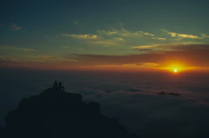 A serene sunset view with two silhouettes sitting side by side
