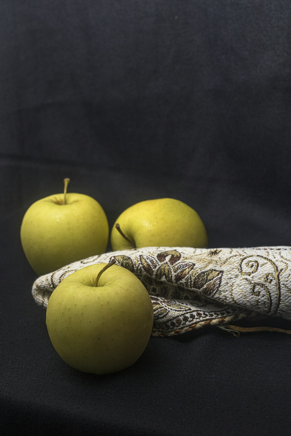 green apple fruit beside silver textile