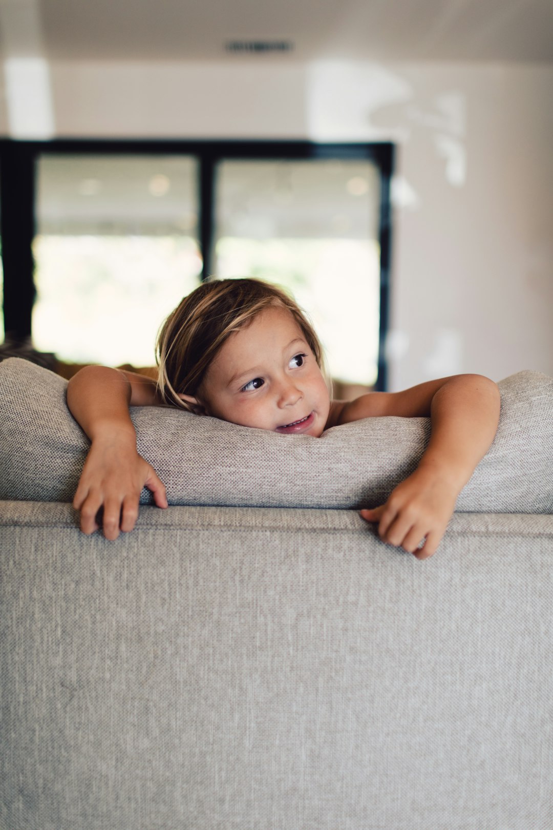 girl lying on gray couch