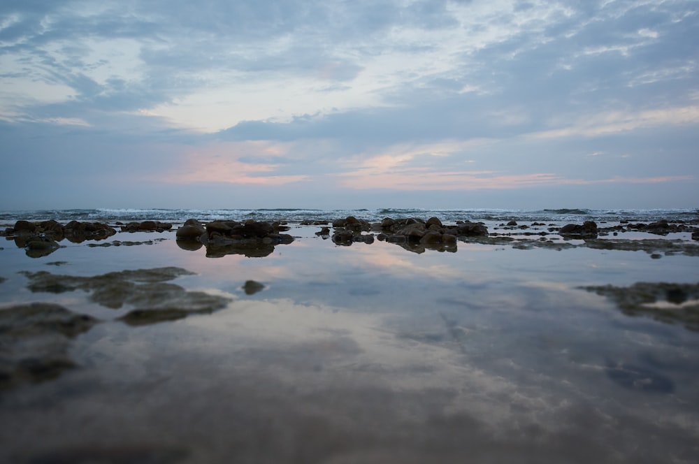 body of water under cloudy sky during daytime