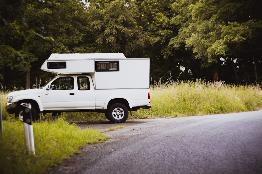 white van on road near green grass field during daytime