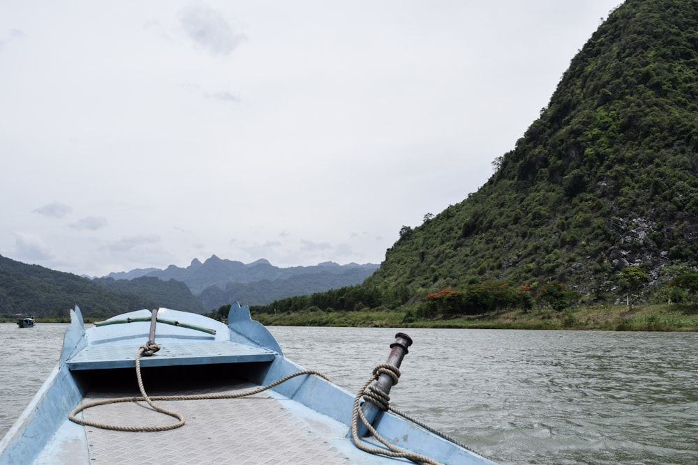 white and blue boat on body of water during daytime