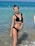 A happy customer wearing a stylish bikini from Trinna Fem at the beach.