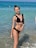 A happy customer wearing a stylish bikini from Trinna Fem at the beach.
