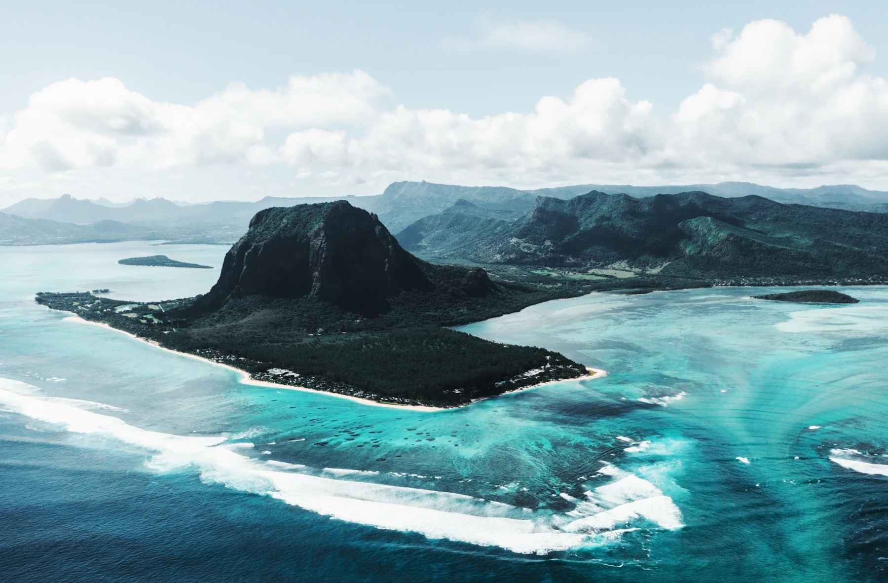 Green mountain rising beside a turquoise lagoon in Mauritius
