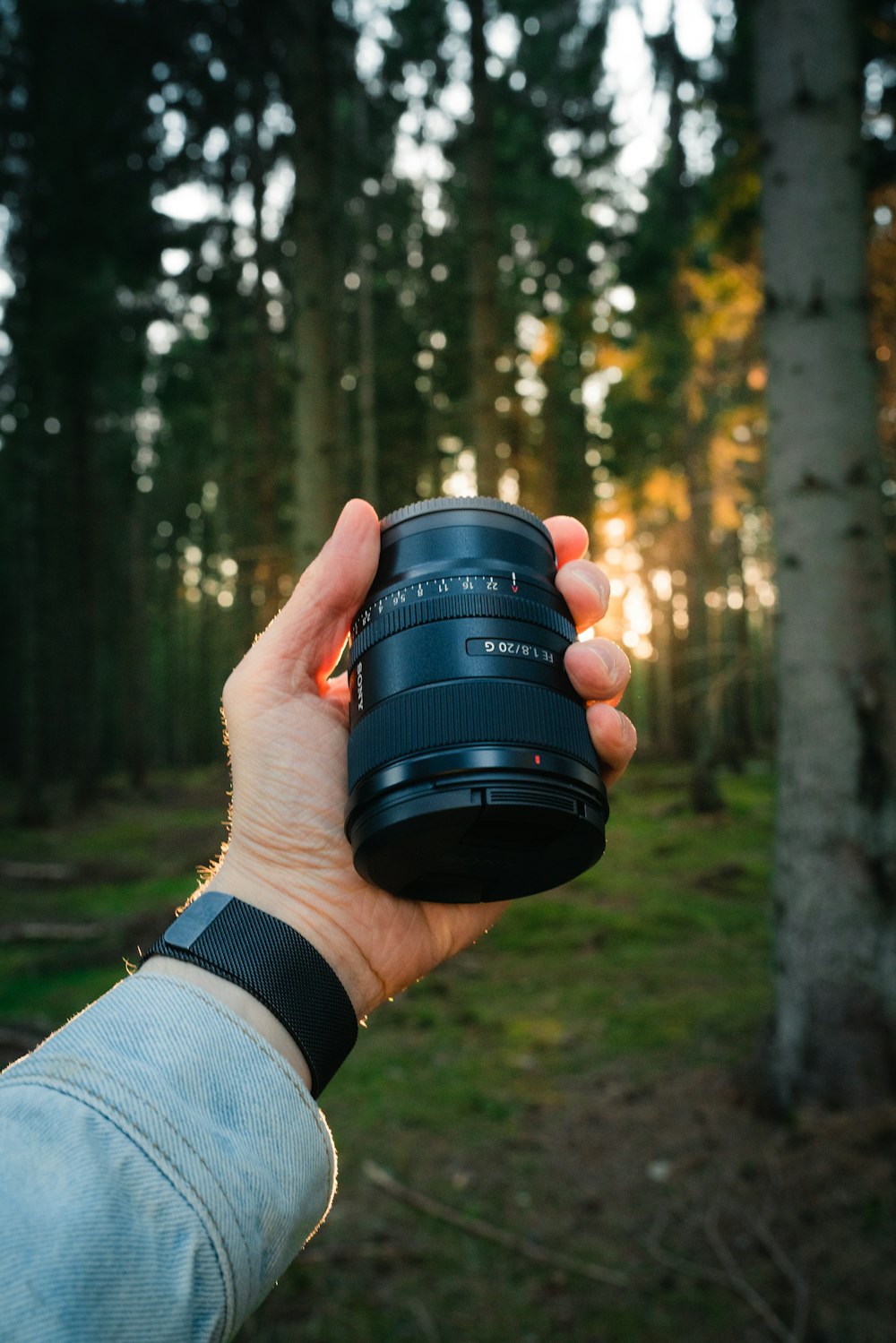 person holding black camera lens