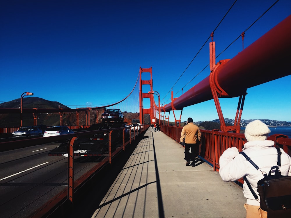 man in white thobe walking on bridge during daytime