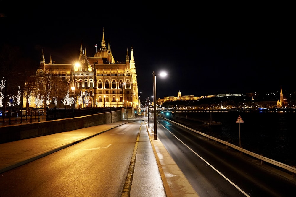 Bâtiment en béton brun près d’un plan d’eau pendant la nuit