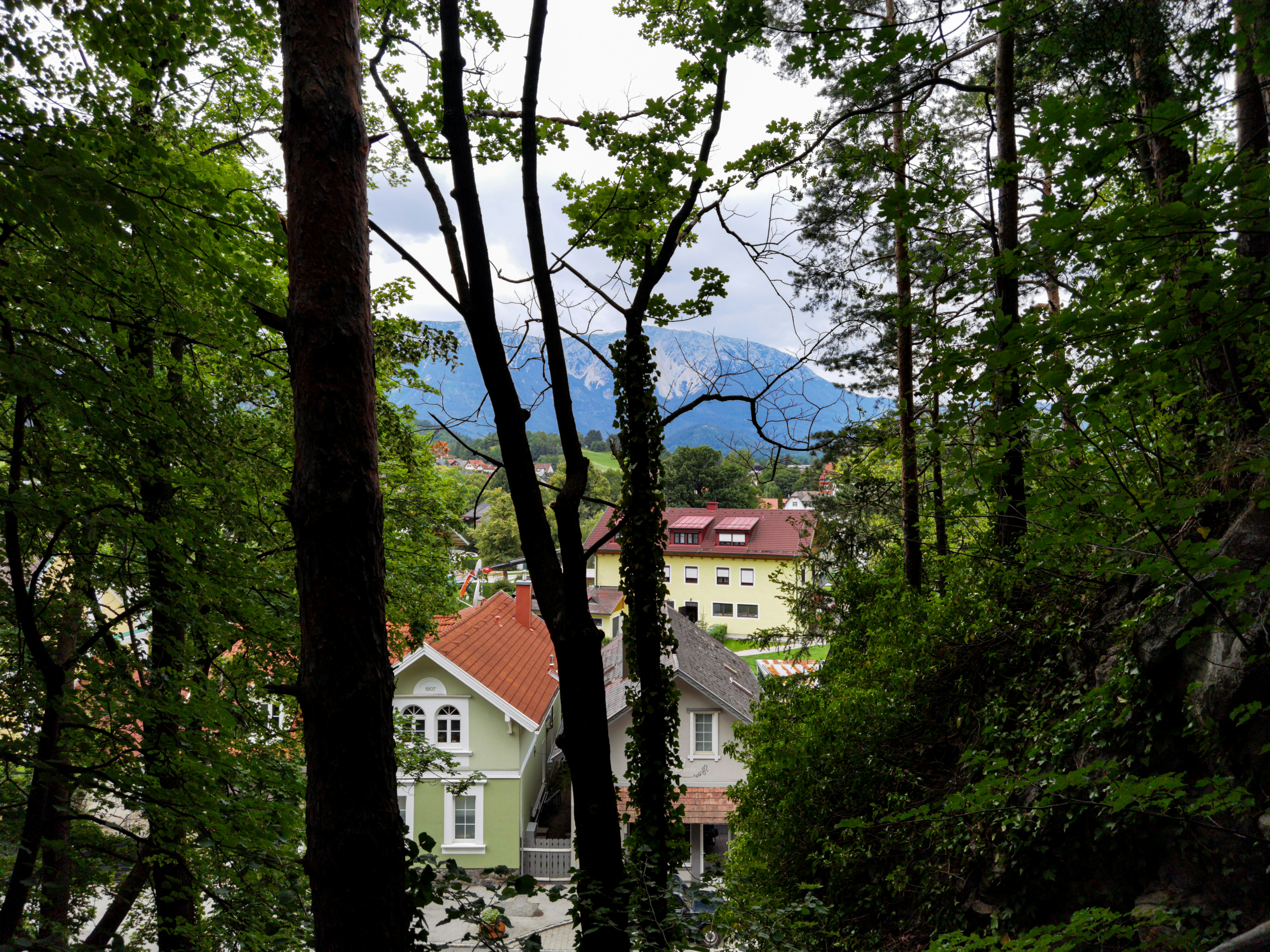 Weißes und rotes Betonhaus in der Nähe von grünen Bäumen tagsüber