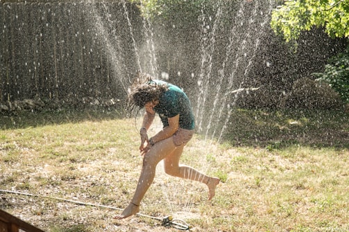 girl in blue shirt playing water