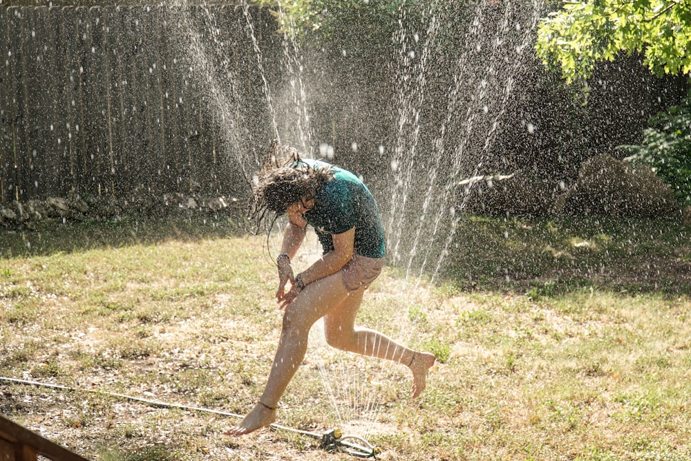 girl in blue shirt playing water