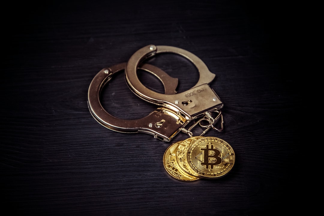 Golden bitcoins and handcuffs on black wooden tbackground