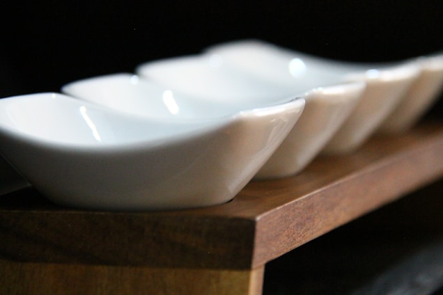 A close-up of polished ceramic sanitary fittings arranged neatly on a wooden surface, reflecting craftsmanship and quality.