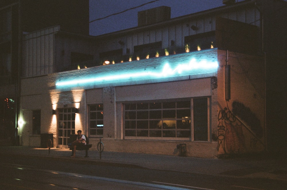 people walking on sidewalk near building during night time