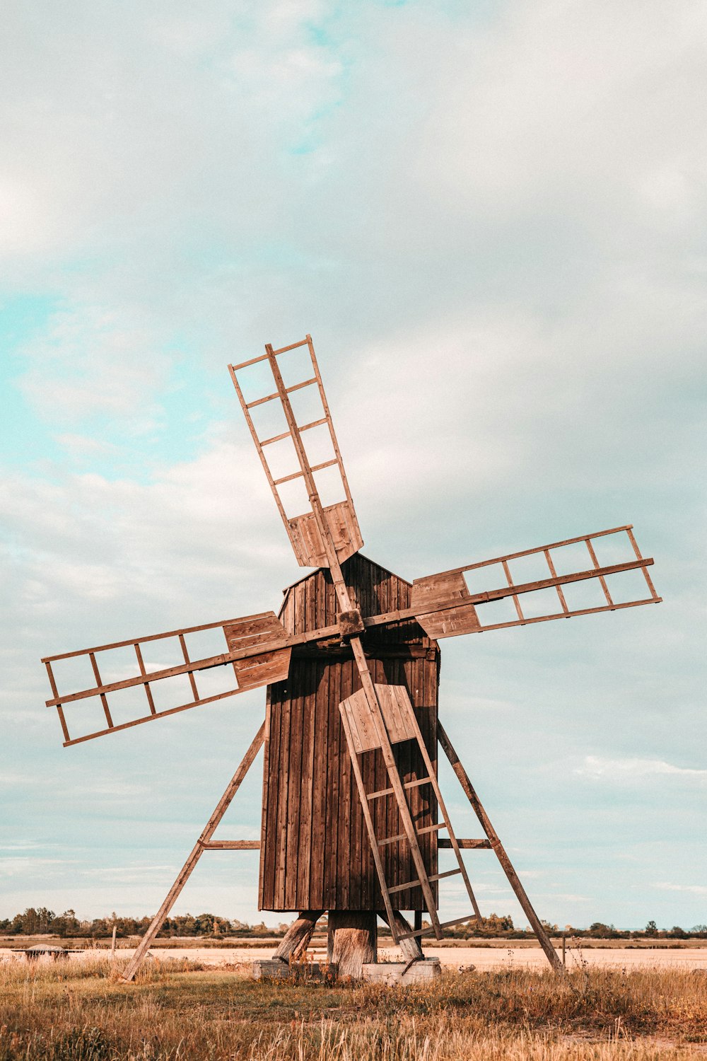 brown wooden windmill under blue sky during daytime
