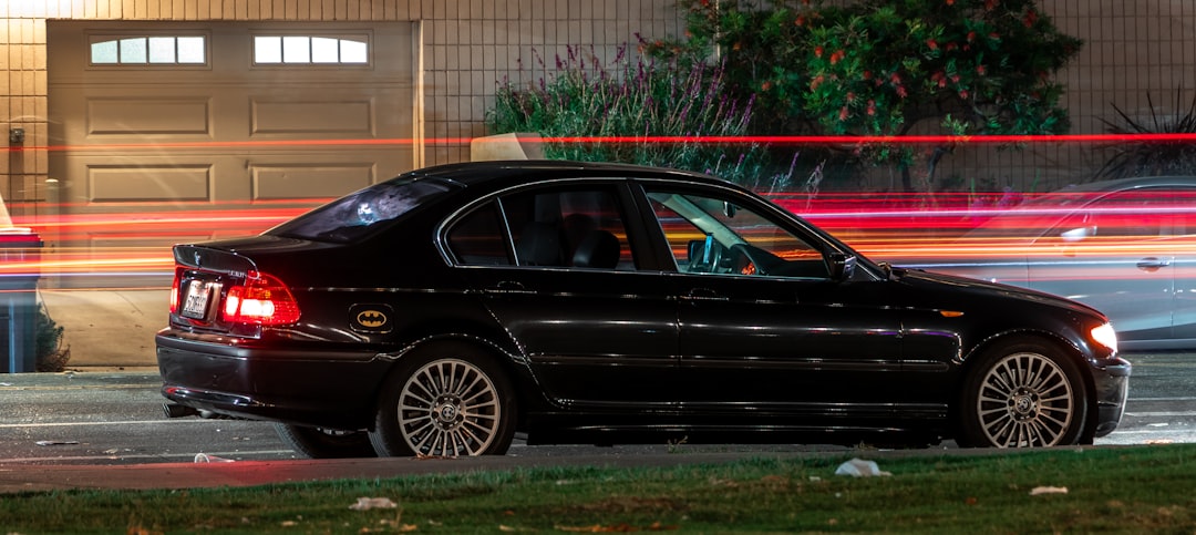 black sedan parked near green grass during daytime