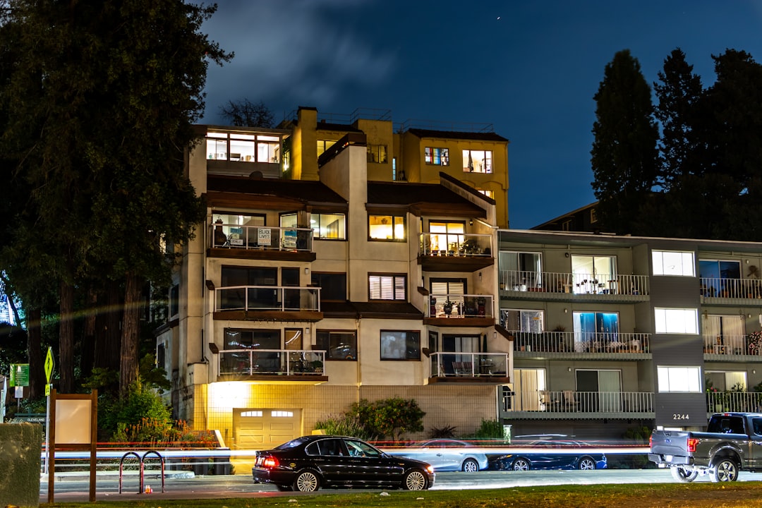 cars parked in front of brown building during night time