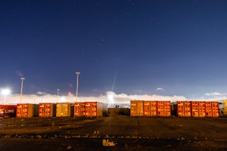 yellow and red cargo containers under blue sky during night time