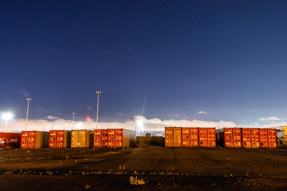 yellow and red cargo containers under blue sky during night time