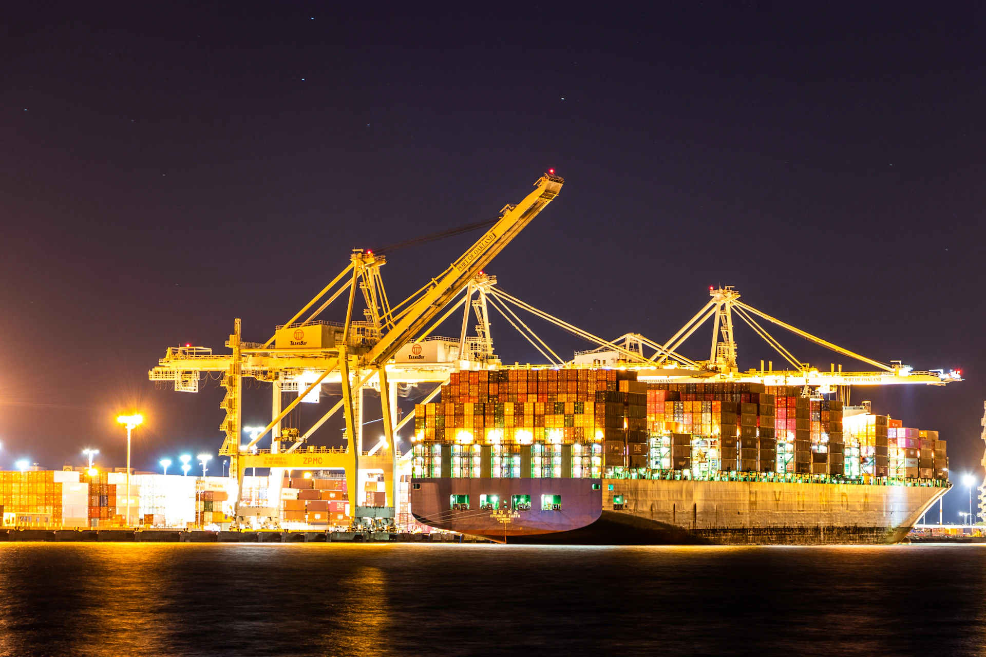 blue and red cargo ship on sea during night time