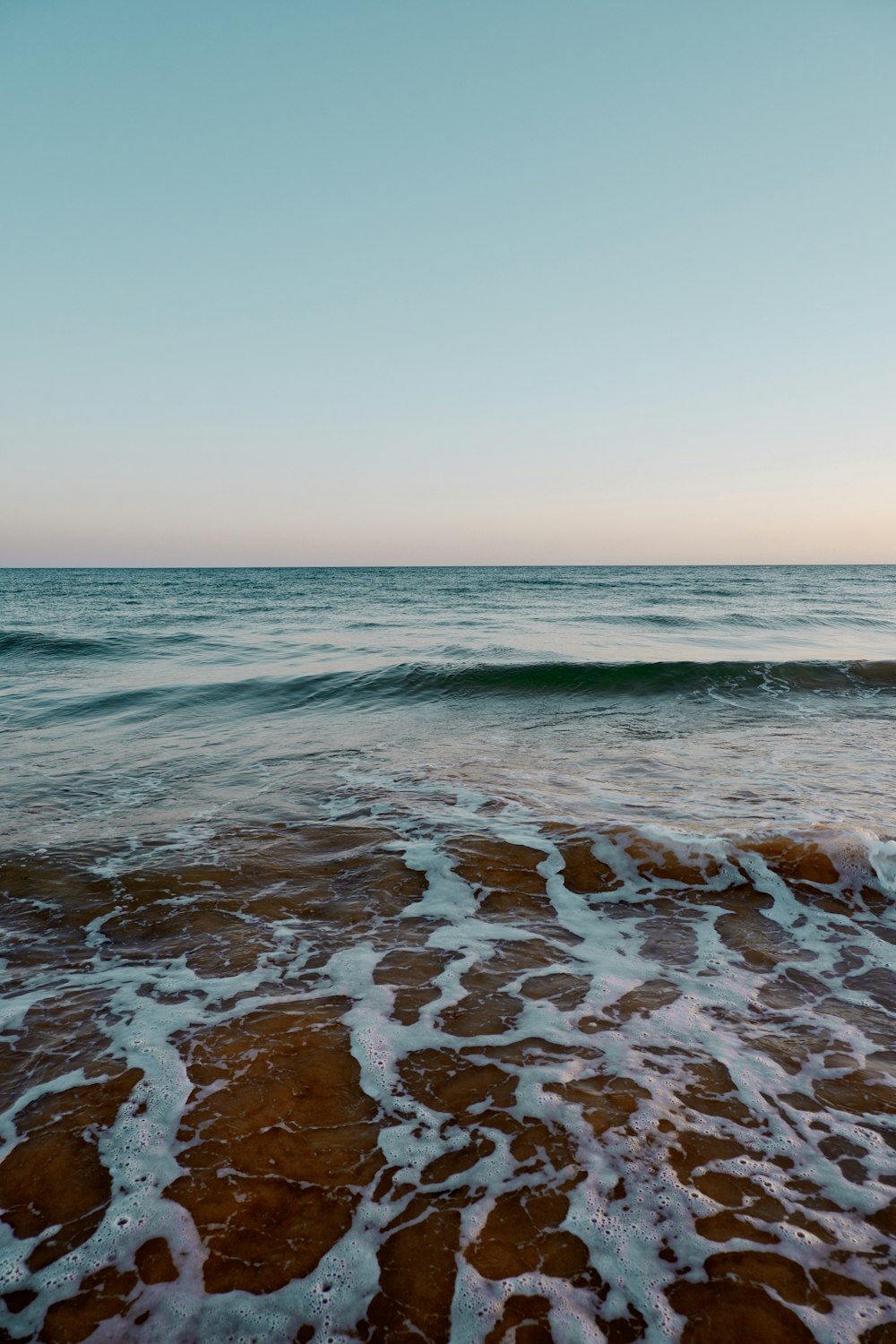 ocean waves crashing on shore during daytime