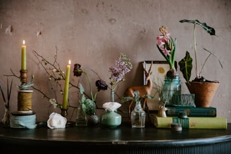 A charming arrangement of home décor items including candles, small plants, and decorative figurines.
