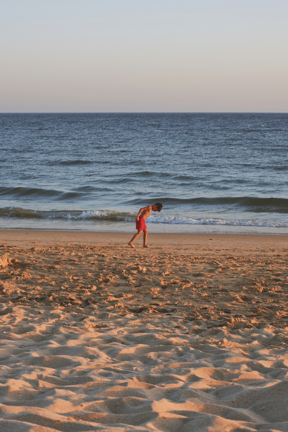 woman in red bikini walking on beach during daytime