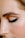 A close-up of a person's face focusing on the eye area, showcasing a perfectly shaped eyebrow and eye makeup with sleek black eyeliner and neutral eyeshadow.