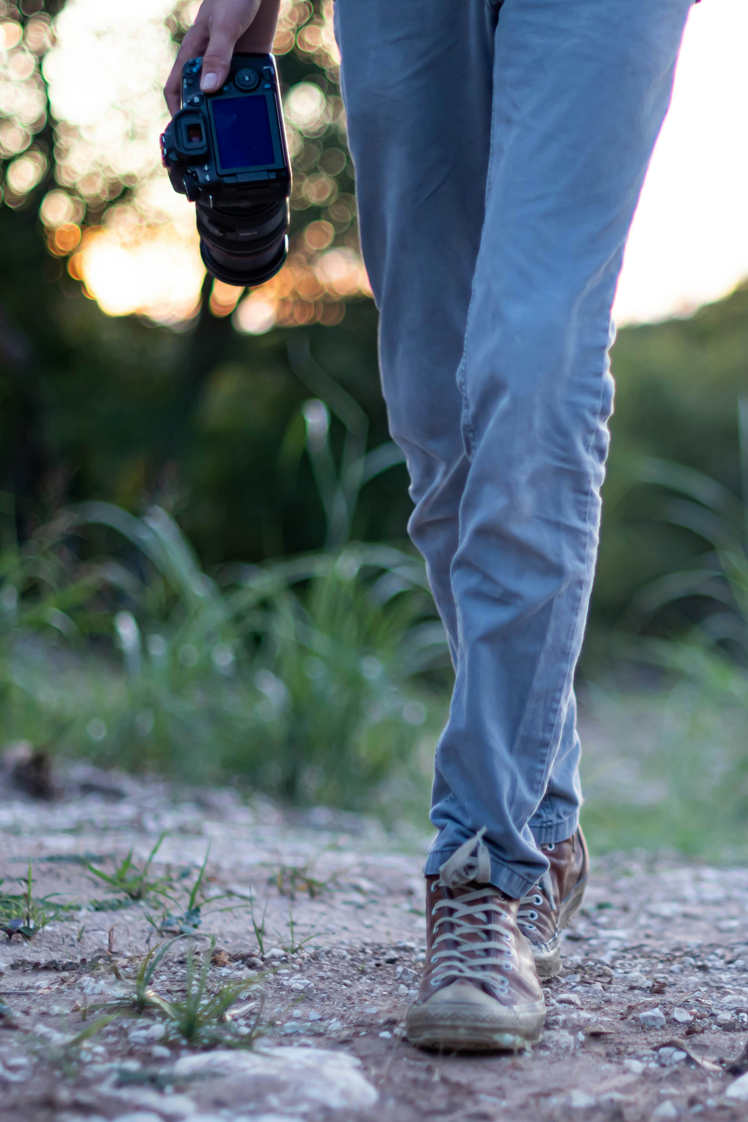 青いデニム ジーンズと灰色のコンクリート舗装の上に立っている茶色の靴の人の写真 Unsplashで見つけるウェイコの無料写真