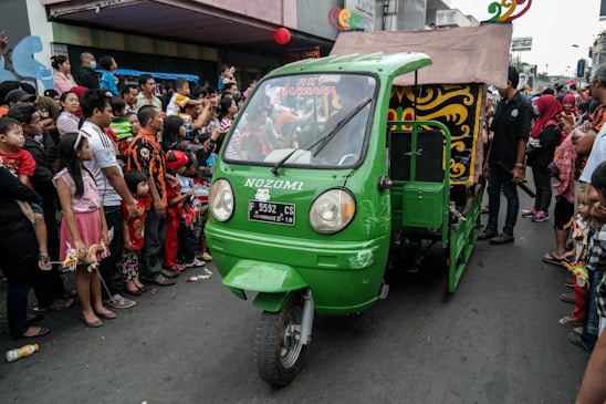 A diverse group of Big Giant Rides drivers and merchants smiling together in a vibrant city street setting.