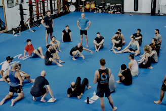 Group sitting in a circle on a blue mat