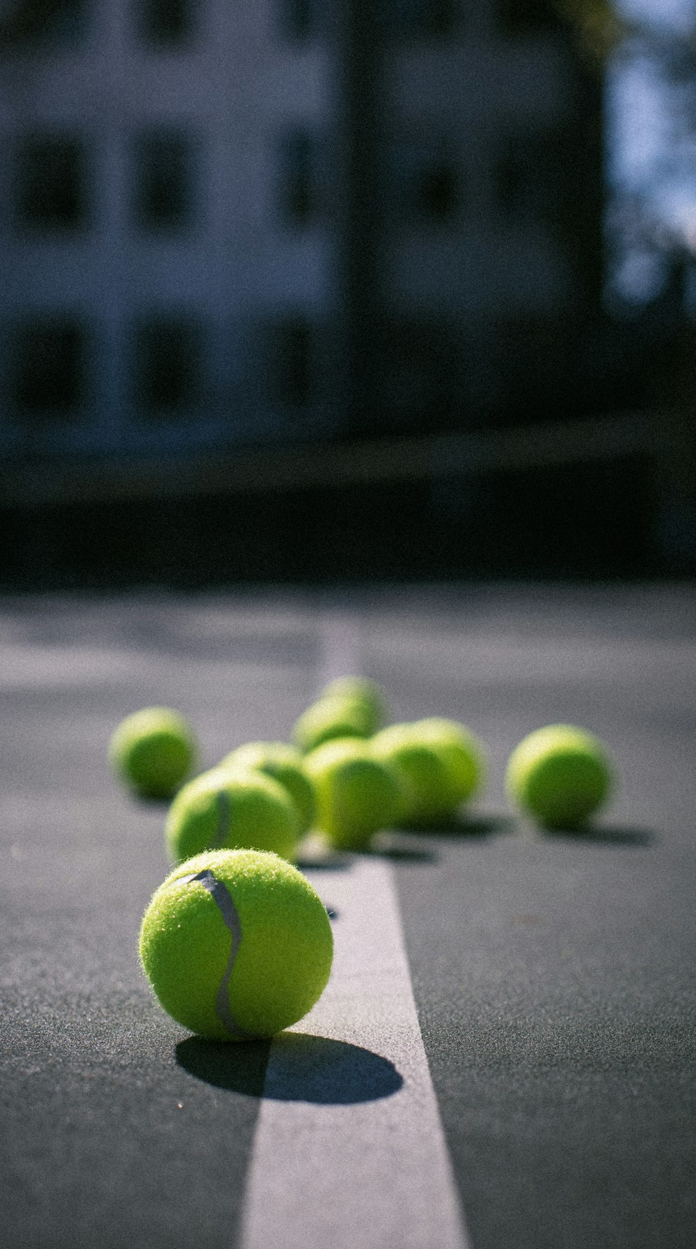 balle de tennis verte sur sol en béton gris