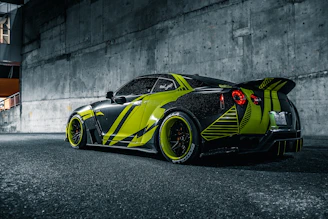 A sleek, shiny semi-new car parked in an urban setting with green and black accents.