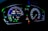 A digital car dashboard displaying various indicators and metrics including speed, power, remaining kilometers, fuel consumption in liters per 100 kilometers, and temperature. The dashboard is illuminated with neon-like blue and green lights, showing additional symbols and alerts related to driving mode and car status.