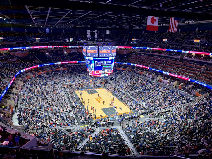 A vibrant crowd cheering at a packed stadium during a thrilling basketball game.