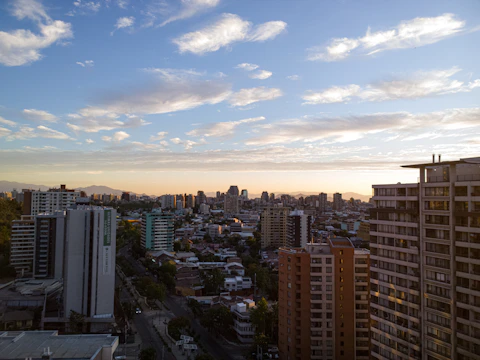 A panoramic view of a modern Hyderabad skyline at sunset showing residential towers.