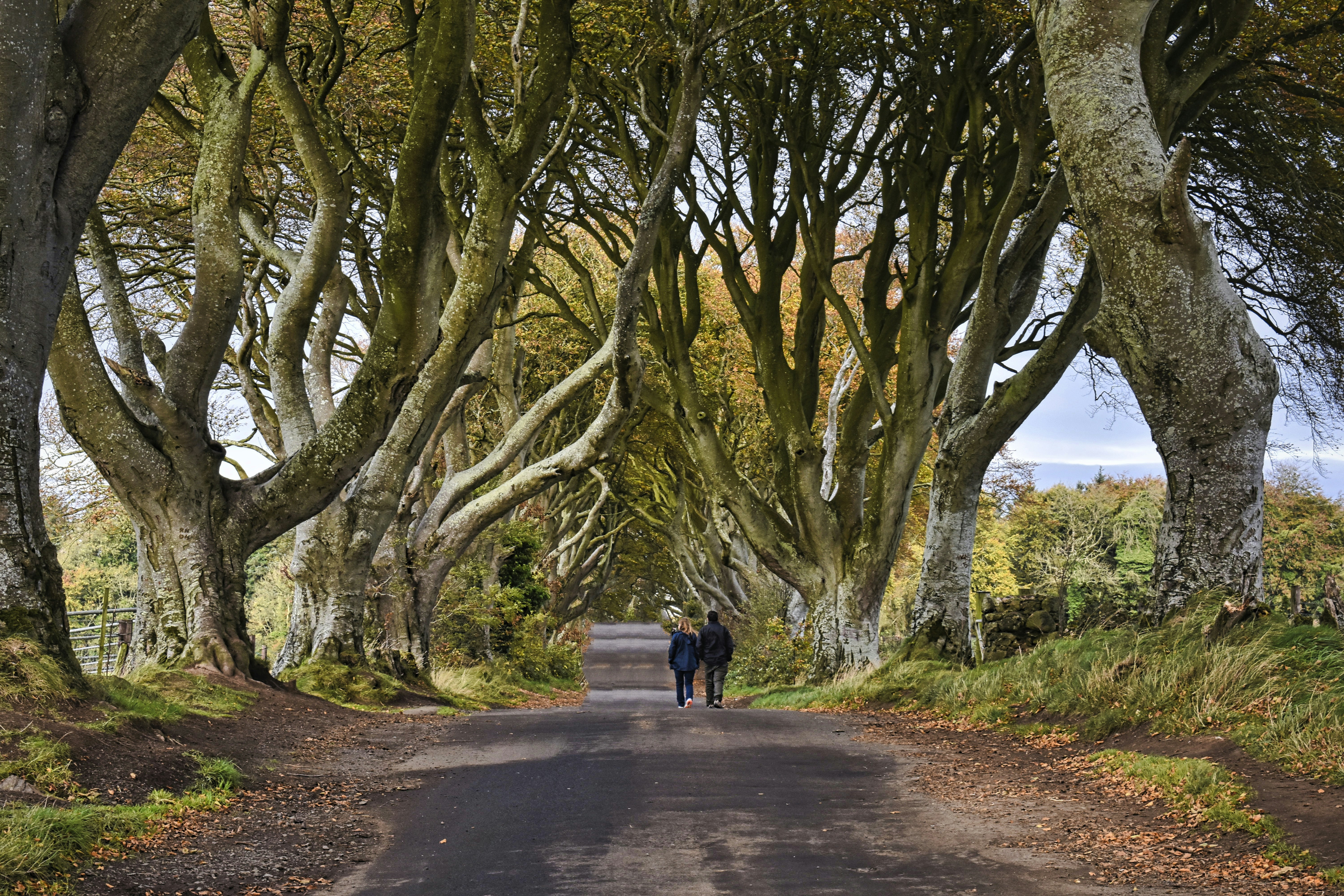 man in black jacket walking on gray concrete road during daytime