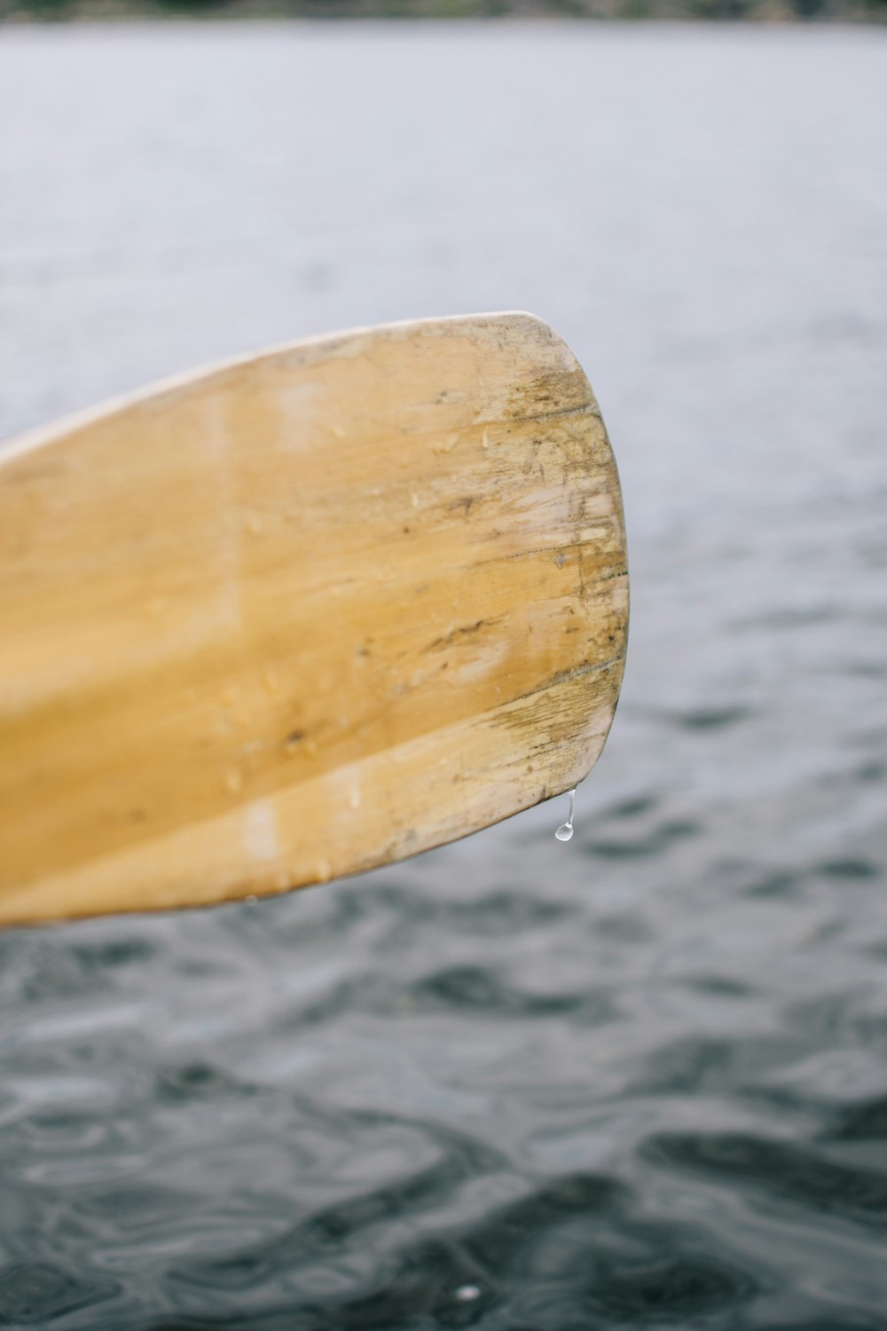 brown wooden surfboard on body of water during daytime