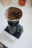 Overhead shot of a coffee setup with a pour-over dripper, fresh grounds, and a mug.