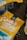 A close-up of a yellow coffee bag with the logo 'Oak & Bond Coffee'. The focus is on the branding, with coffee beans scattered around on a wooden table, creating a rustic and inviting atmosphere.