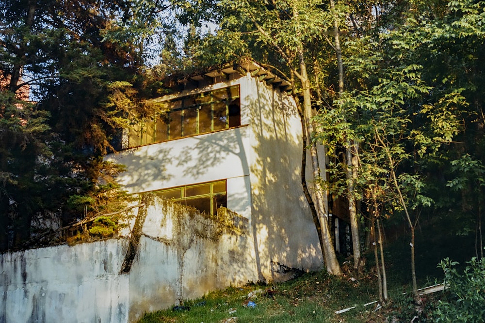 white concrete house surrounded by green trees during daytime