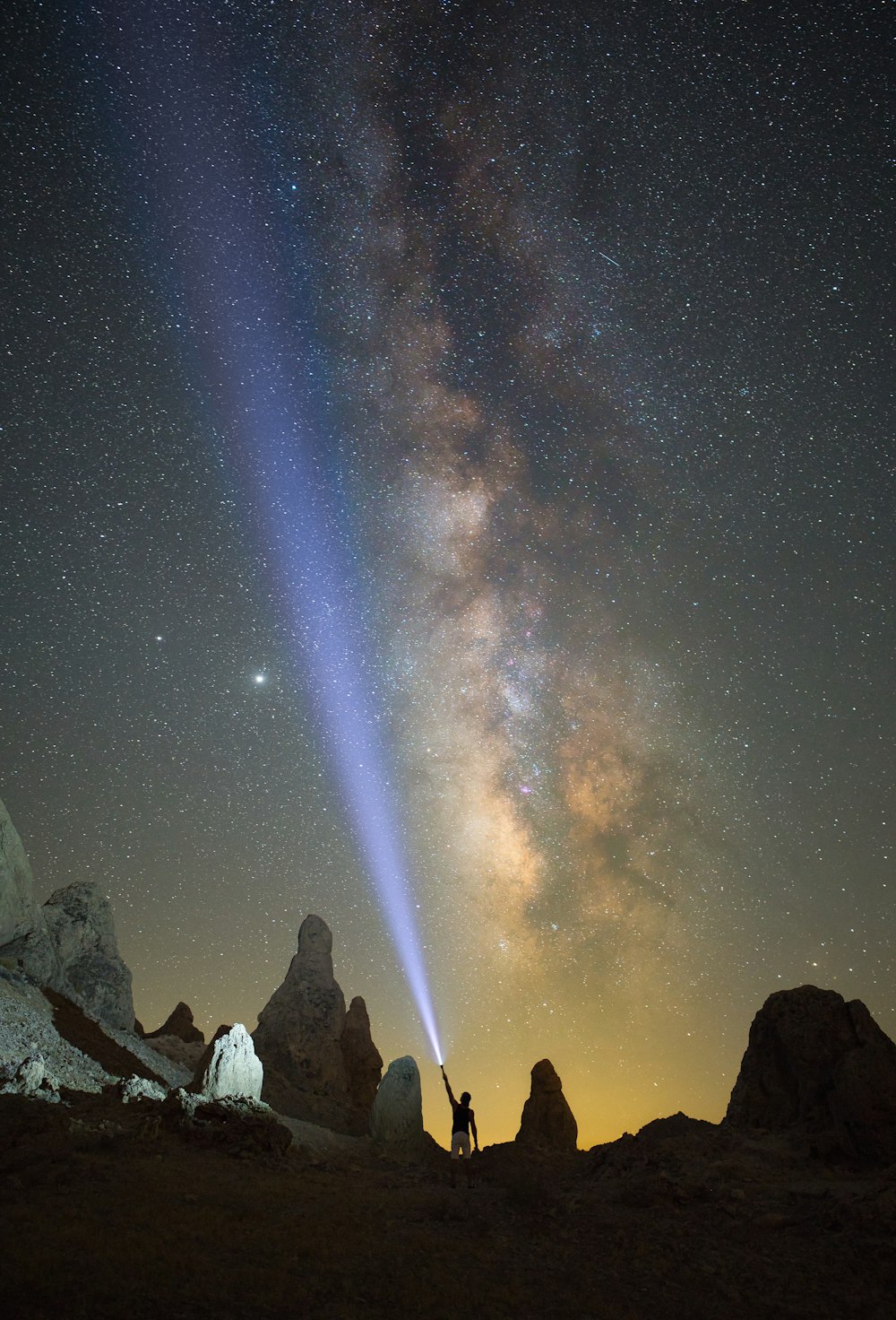 Persone in piedi sulla collina rocciosa sotto la notte stellata