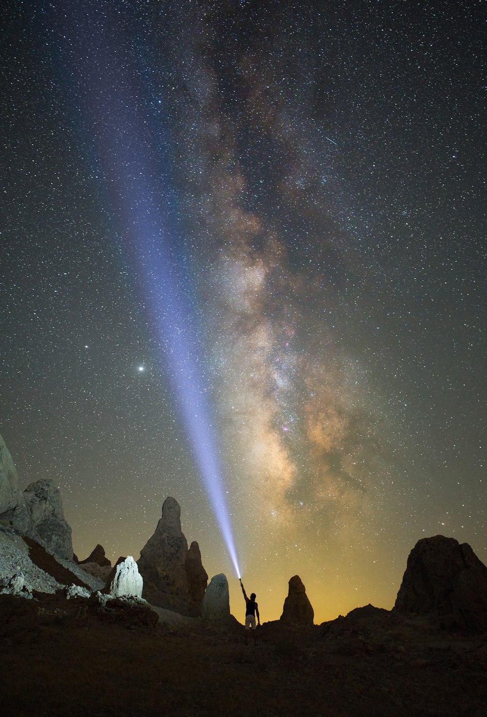 Gente de pie en la colina rocosa bajo la noche estrellada